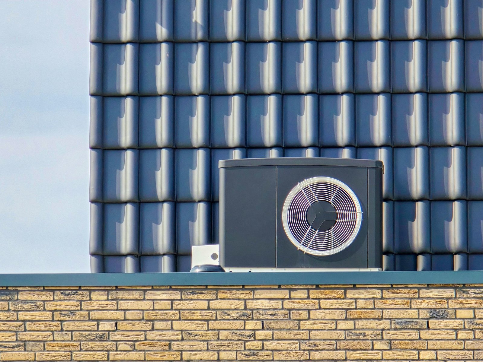 air source heat pump unit installed outdoors at a modern home with bricks in the Netherlands